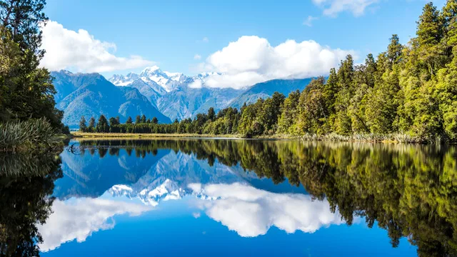 Peaceful mountain lake with stunning reflections a — Seguro de viaje para Nueva Zelanda